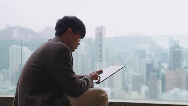 Businessman using tablet resting on roof top