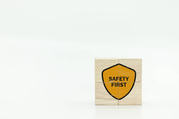 Shield icon and safety text on wooden cubes with white background.Safety first symbols, work safety, caution work hazards, danger surveillance, zero accident concept. Employees safety awareness icono de escudo y texto de seguridad en cubos de madera con fondo blanco. símbolos de seguridad primero, seguridad laboral, precaución riesgos laborales, vigilancia de peligros, concepto de cero accidentes. concienciación sobre la seguridad de los emple