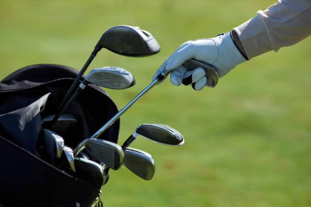 крупный план игрока в гольф, выбирающего клюшку - iron стоковые фото и изображения