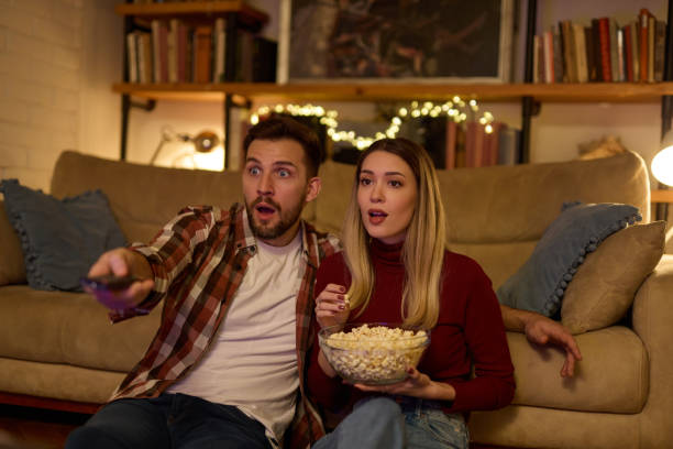 istock Young romantic couple watching TV at home 1477184967