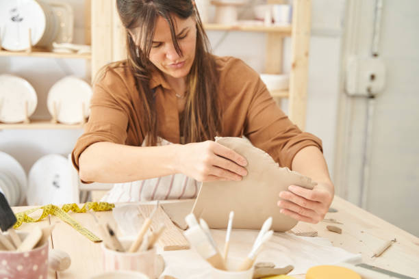 istock Woman painting and decorating a pottery in a ceramic workshop. 1477185585