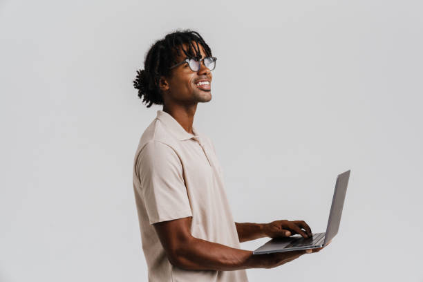 istock Profile of young african man in eyeglasses using laptop 1477185982