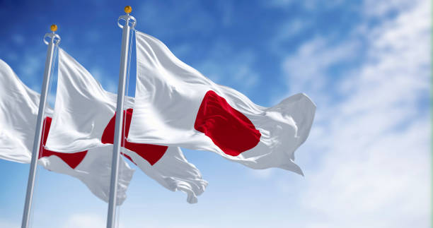 tres banderas nacionales de japón ondeando en el viento en un día despejado - japan flag three dimensional shape japanese flag fotografías e imágenes de stock
