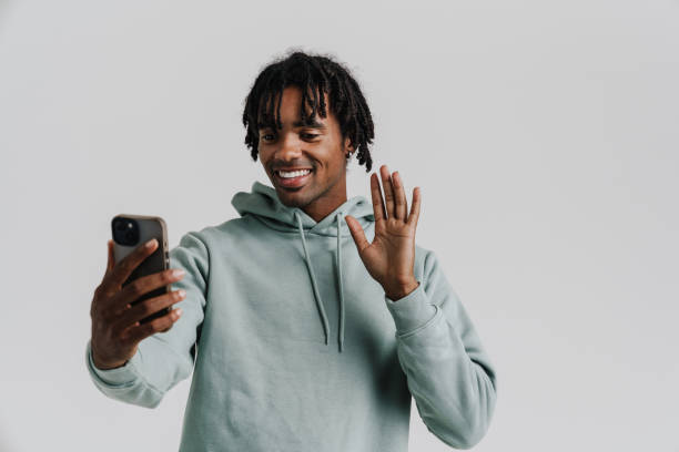 istock Black young man gesturing while taking selfie photo on cellphone 1477186887