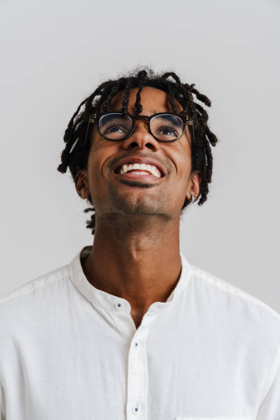 istock Black young man in eyeglasses smiling while looking upward 1477188151