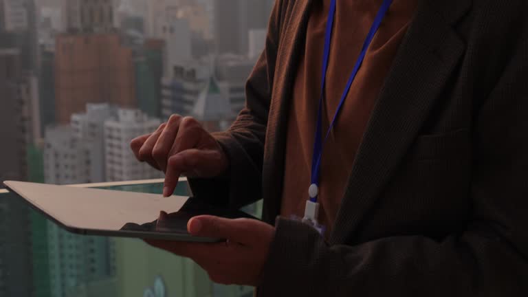 Businessman using tablet on roof top with sunset time
