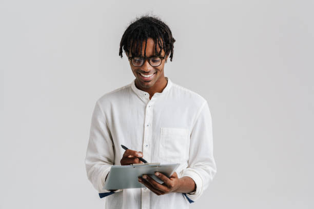 istock Smiling young man writing in clipboard isolated over white background 1477188654