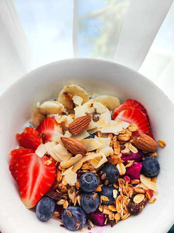 Close up shot of Homemade healthy smoothie fruit bowl, with granola, variation nuts, blueberry and strawberry