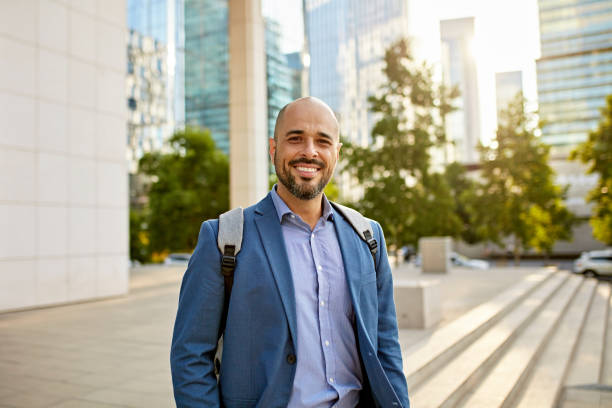 Cheerful Hispanic businessman outside office building