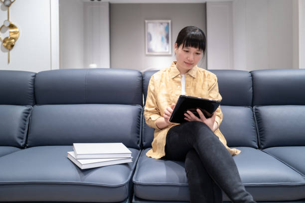 istock A woman sitting on the sofa reading a book 1477189301