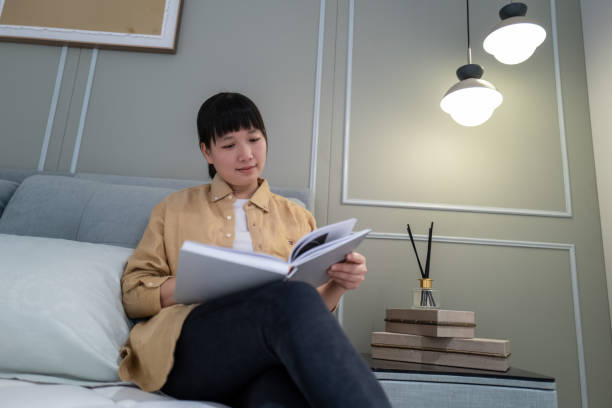 istock A woman sitting on the sofa reading a book 1477189408