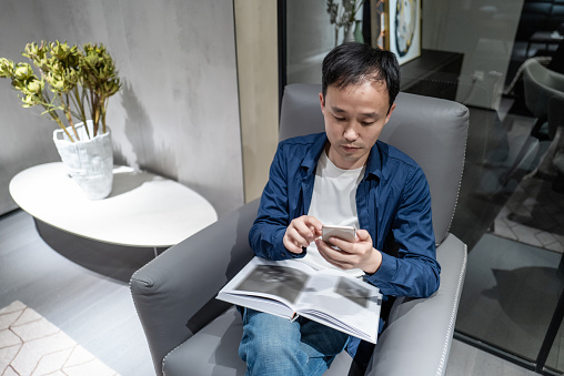 A man sitting on the couch using a mobile phone