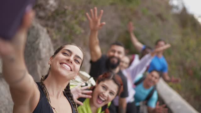 Mid adult woman taking a selfie with her friends during a hike outdoors