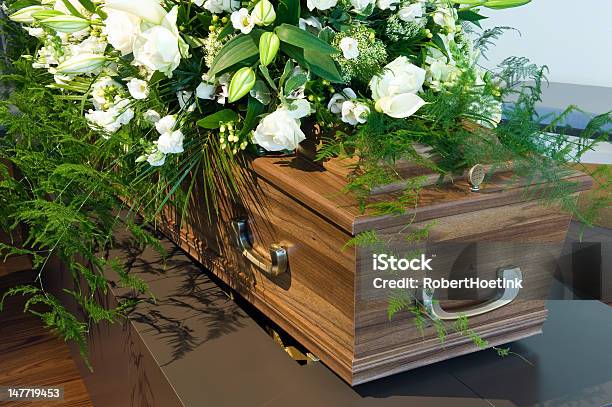 Wooden Coffin In A Morgue With White Flowers Stock Photo - Download Image Now - Coffin, Funeral, Undertaker