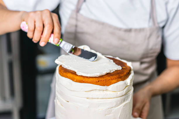 istock Colombian Pastry Chef. Chef spreading the cream cheese. 1477195067