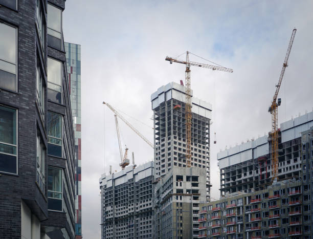 View of a new building with working cranes stock photo