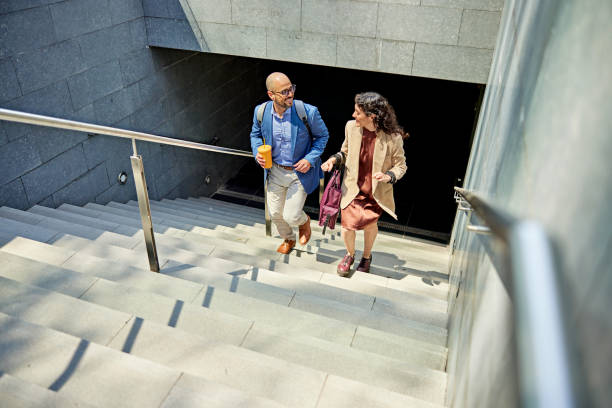 Smiling business partners walking up staircase stock photo