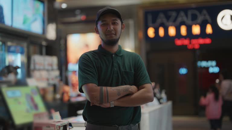 Portrait of hipster man waitress working in cinema theater.