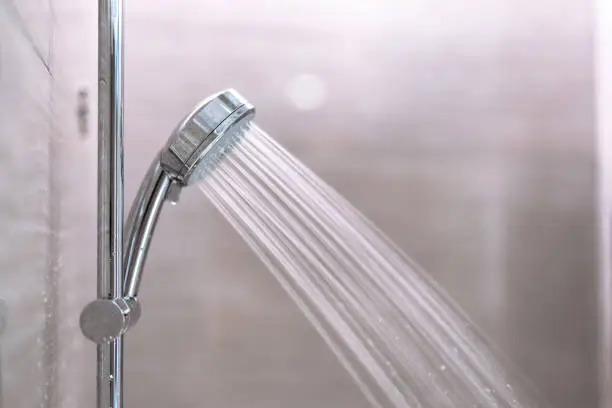 Photo of Shower head was installed on the wall in the bathroom, Water flowing out of the shower.