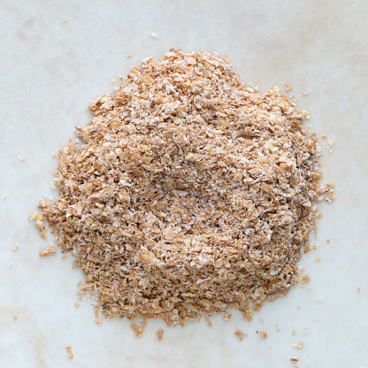 Extreme close-up view of heap of bran in high angle view of the camera.Image made in studio with white background