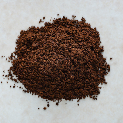 Extreme close up view of ground coffee on white background