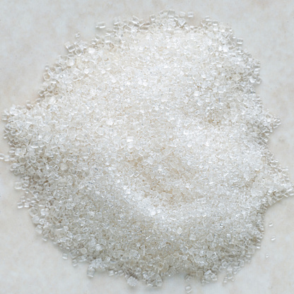 Pile of sugar on ceramic background. Extreme close up macro photography .Image made in studio.