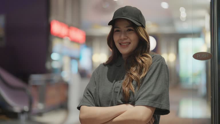 Portrait of young woman waitress working in cinema theater.