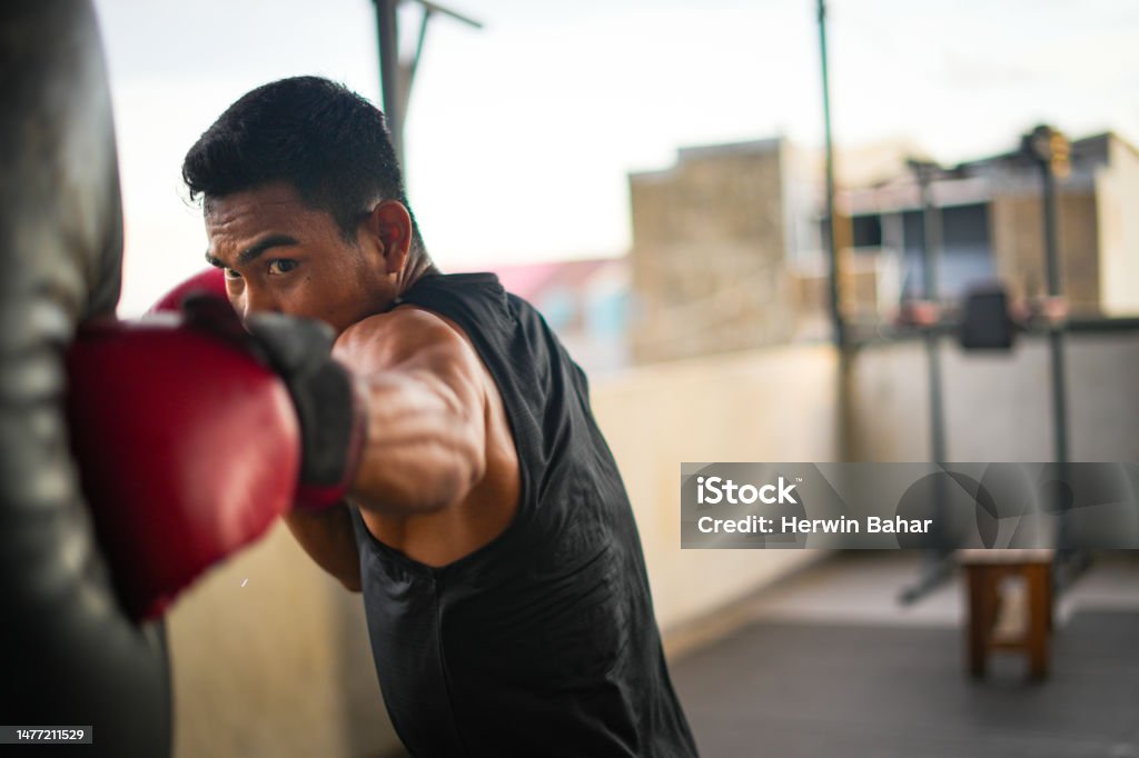 Portrait of young male boxing athlete Portrait of young male boxing athlete training in training room Exercising Stock Photo