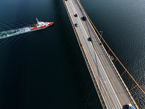 A coast guard vessel beneath a suspension bridge.