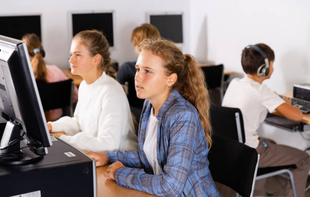 istock Teenage boys and girls using computers in IT class room 1477220755