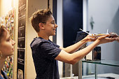 Teenage boy buying crepes with chocolate
