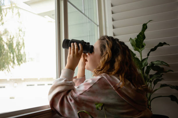 dziewczyna wyglądająca przez okno przez lornetkę - looking through window lens tourist image zdjęcia i obrazy z banku zdjęć