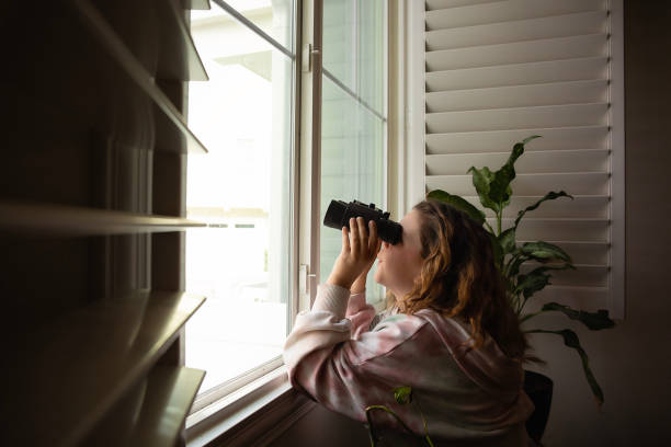 dziewczyna wyglądająca przez okno przez lornetkę - looking through window lens tourist image zdjęcia i obrazy z banku zdjęć