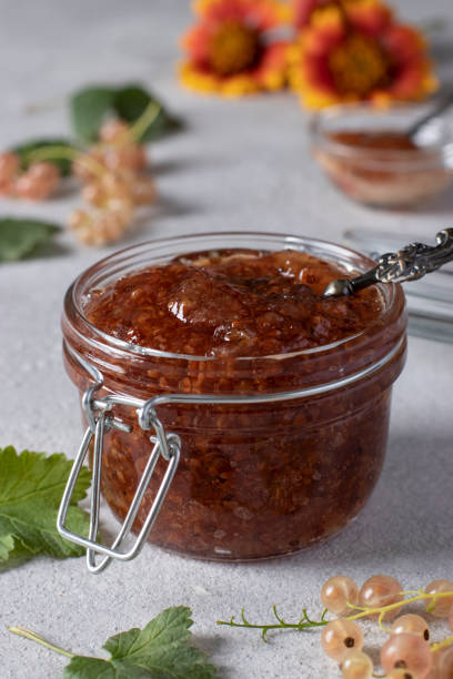 istock Homemade white currant jam in glass jar on light gray background 1477230676