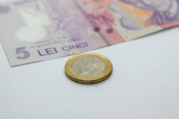 close up de uma moeda de euro perto de uma nota de 5 leis. taxa de câmbio romena para a moeda da união europeia - euro symbol european union currency coin european union coin - fotografias e filmes do acervo