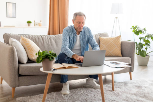 istock Confident casual mature using laptop at home 1477233910