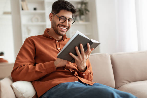 istock Smiling Arab man in glasses reading book 1477233931