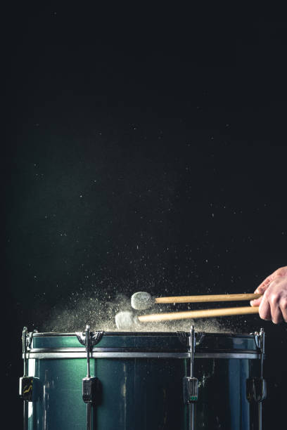 istock A man plays a musical percussion instrument with sticks on a dark background. 1477239640