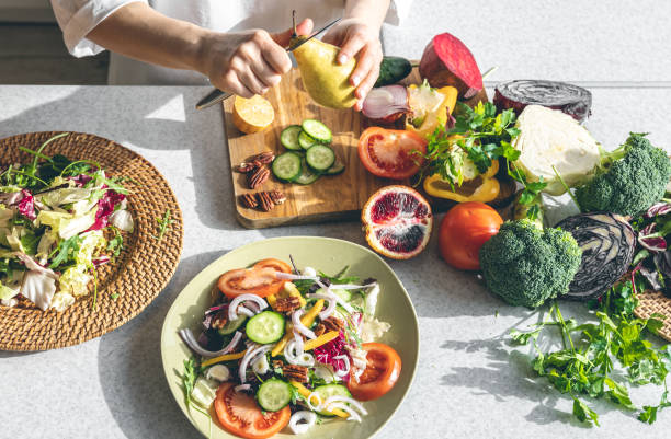 istock A woman makes a fresh vegetable salad, close-up. 1477241188