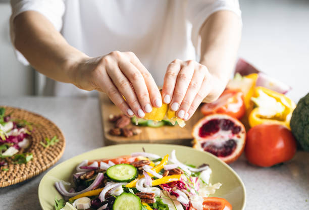 istock A woman makes a fresh vegetable salad, close-up. 1477241190