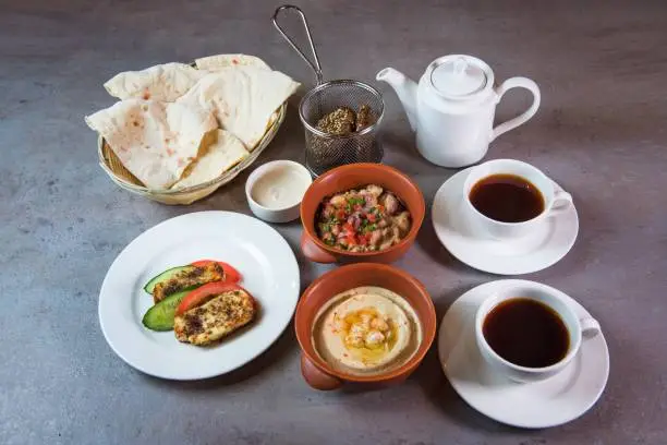 Bahrain Breakfast with hummus, beans, bread, coffee served in dish isolated on grey background top view of bahrain food