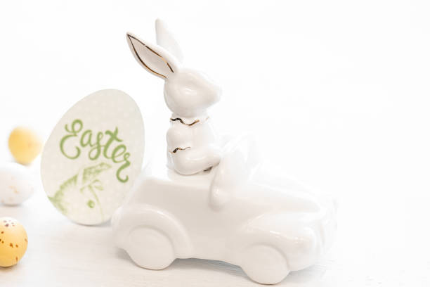 istock Easter background with a ceramic hare in the car and eggs on a white background, 1477242665
