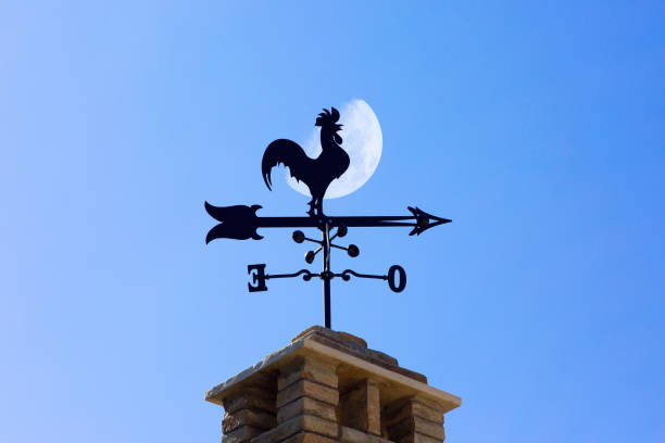 silhoutte de una veleta en un techo con cielo azul y la luna - roof roof tile rooster weather vane fotografías e imágenes de stock