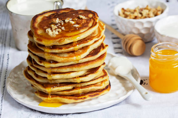 istock Apple pancakes served with honey, sour cream, nuts, tea and coffee. 1477243320