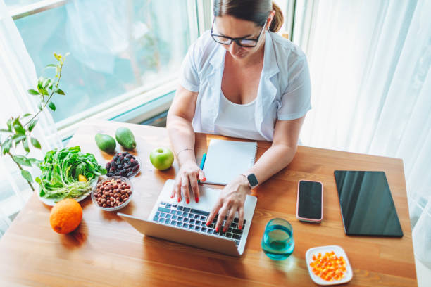 istock Nutritionist female doctor working using laptop writing diet plan 1477247829
