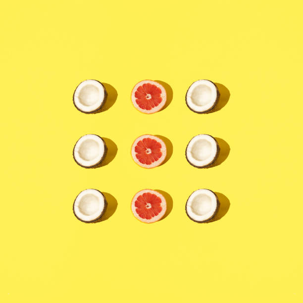istock Half coconut and grapefruit on a pastel background. Background yellow color. 1477251752