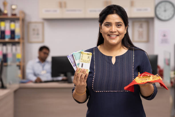 portrait of happy woman showing gold jewelry for gold loan in bank stock photo - jewelry paper currency gold currency imagens e fotografias de stock