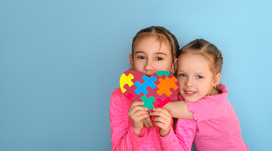 Children hold an autism symbol in their hands as a sign of support for special people with disabilities. A banner with an empty space for text.