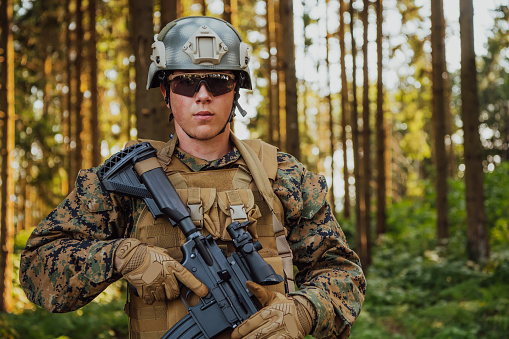 Un soldado de guerra moderno en servicio de guerra en áreas forestales densas y peligrosas. Peligrosas operaciones militares de rescate photo
