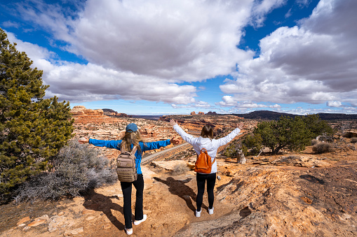 Happy mother and daughter standing on top of the mountain. Potash Road or the Lower Colorado enjoying time. Scenic Byway, Moab, Utah,USA